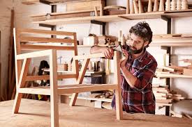 Craftsperson shaping wood in a furniture workshop